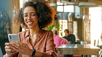 Junge Frau mit Smartphone in einem Café
