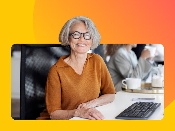 Seniorin mit Brille sitzt an Computer und lernt