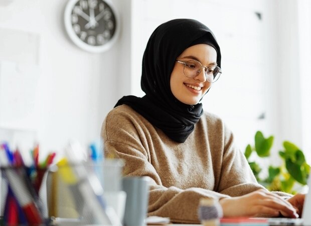 Eine Frau im Büro arbeitet am Laptop.